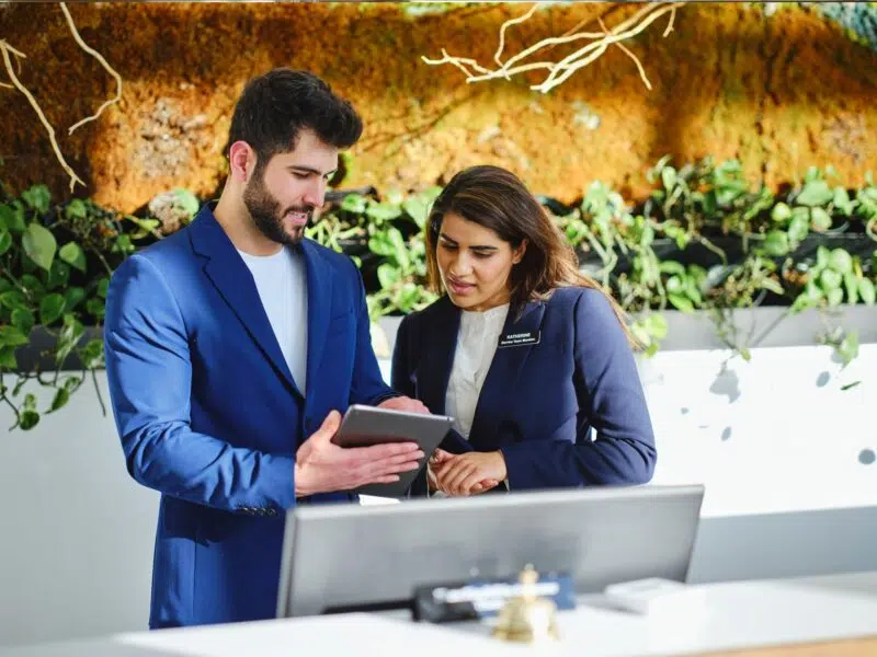 hotel workers looking at scheduling on tablet