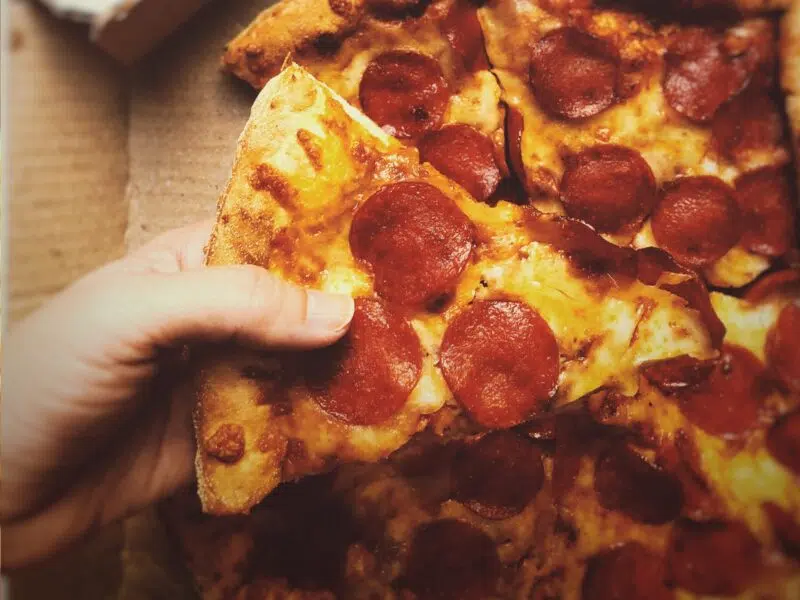 customer eating a piece of pizza