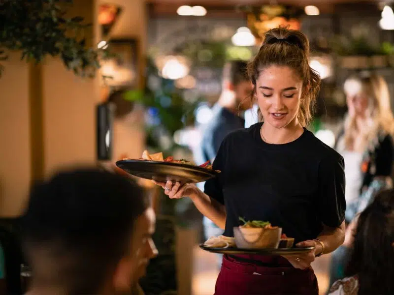 Waitress carrying two plates of food in a restaurant