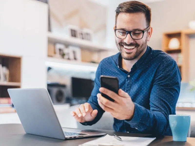 Man using mobile phone and laptop