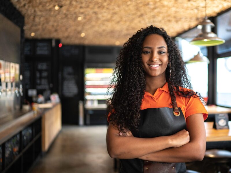Women with arms crossed, restaurant in the background