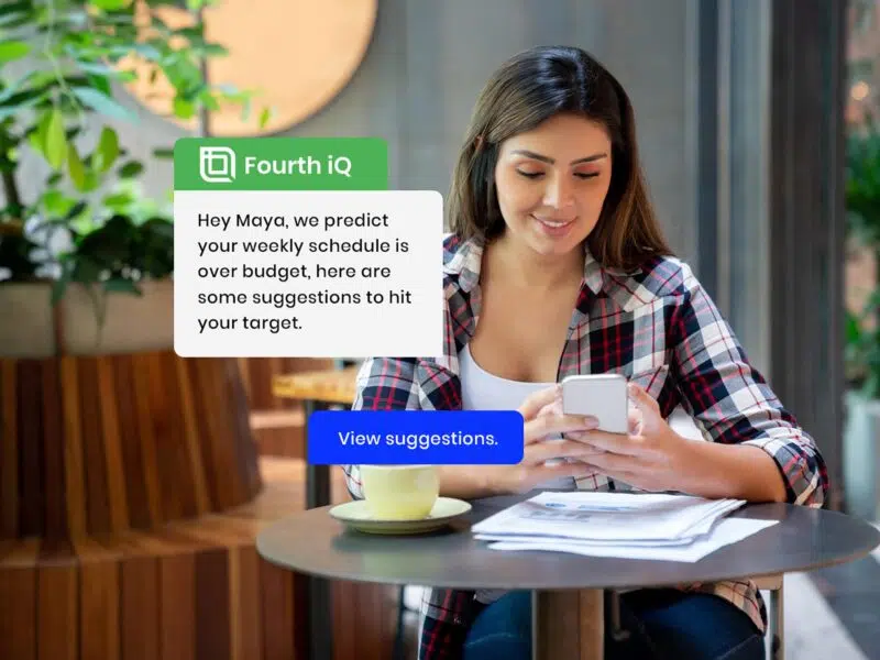Women in restaurant, on phone, alert pops up on phone